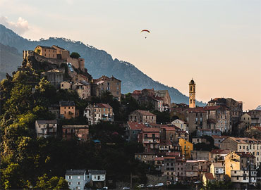 Corse, vue sur Corte et sa citadelle. Après l'orage les ULM sont de sortie.